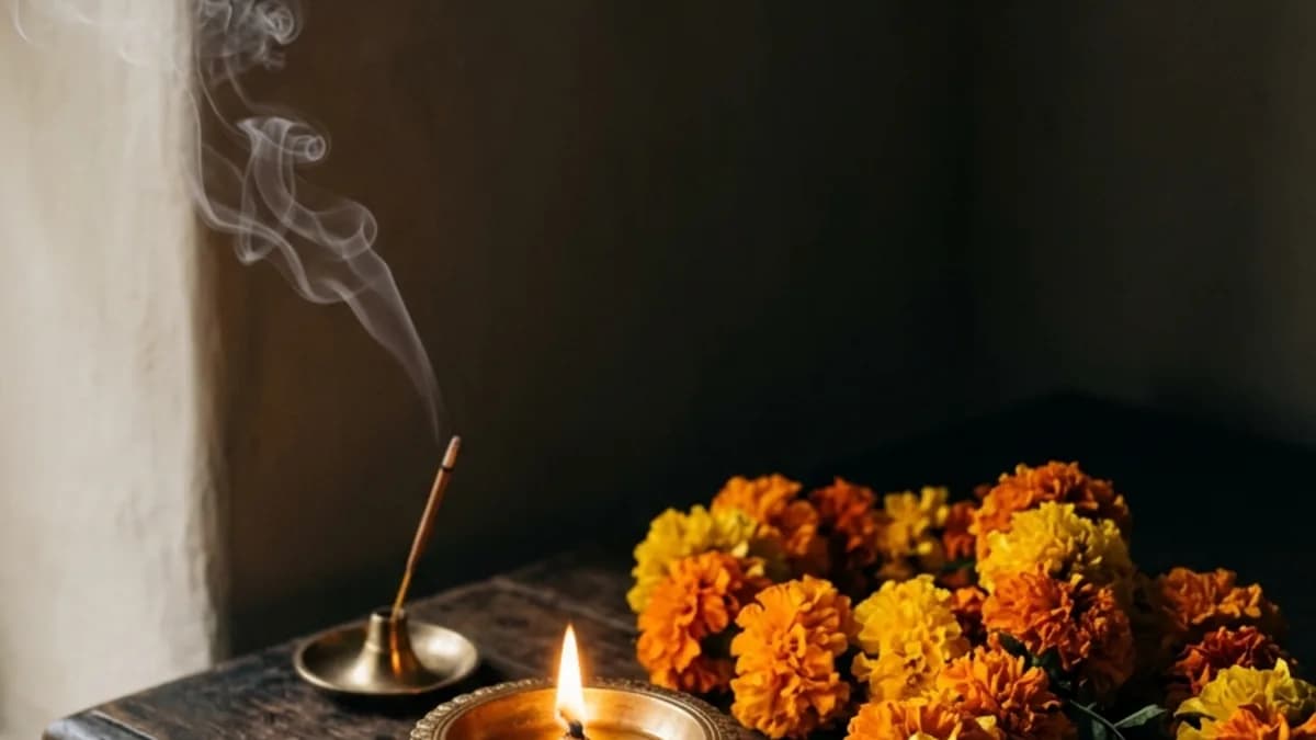 Traditional burning brass diya and golden marigolds for Diwali puja